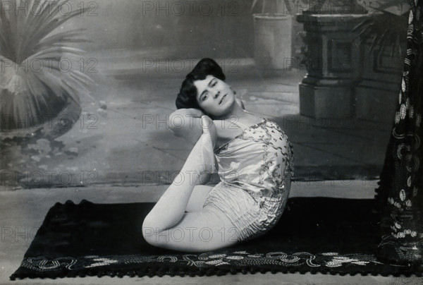 A Bulgarian female acrobat performing contortions in a photographic studio, between 1890 and 1910. Creator: Unknown.