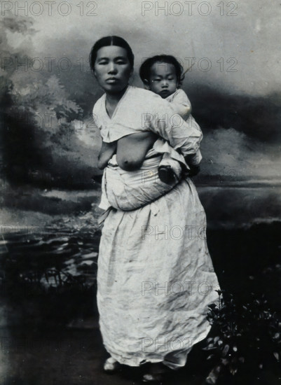 A Korean (?) woman, carrying a baby on her back, approx 1900. Creator: Unknown.