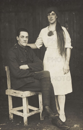 Two prisoners of war, one in drag, pose with a chair, [between 1910 and 1919?]. Creator: Unknown.