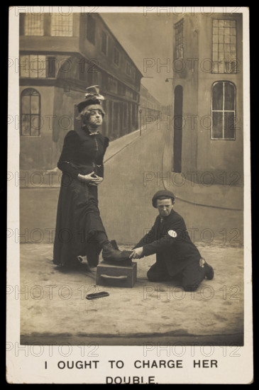 A shoeshine boy cleans the boots of a man in drag, c1905. Creator: Unknown.