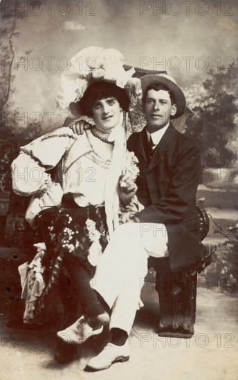 Two men, one in drag, sit together on a bench, (between 1900 and 1901?). Creator: Unknown.