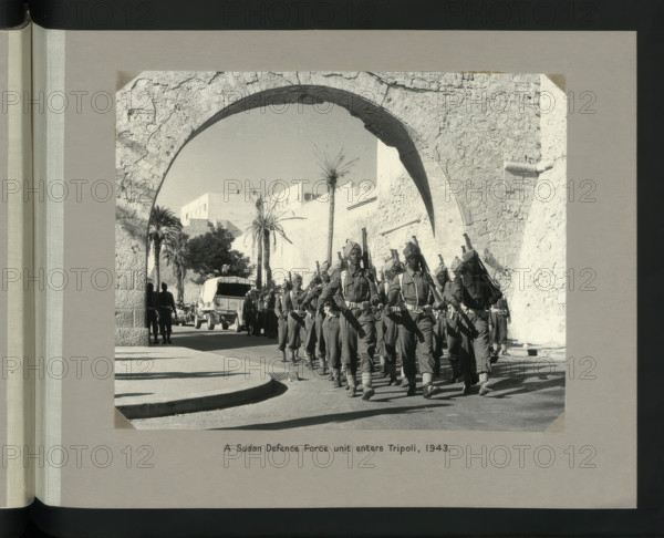 A Sudan Defence Force unit enters Tripoli, 1943. Showing Tripoli Castle on Piazza Italia. Creators: Colonial Office, Unknown.