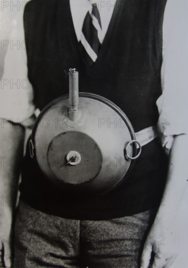 Cecil Vandepeer Clarke wearing an early version of the limpet mine on a keeper plate, c1939.  Creator: British Government.
