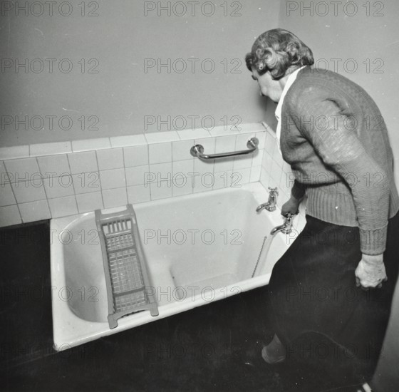 16 Candy Street, Poplar, London: elderly woman in bathroom, 1962. Creator: Unknown.