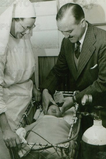 Dr Geoffrey Mutton and Matron Joan Gardner attend to a baby at St Monan's Hospital, c1950. Creator: Unknown.