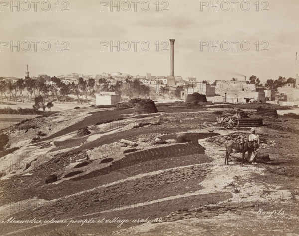 Pompey's Pillar and Arab Village at Alexandria, 19th century. Creator: Maison Bonfils.