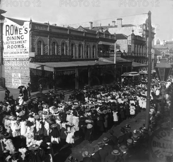 Procession of girls and women out the front of 142, Queen Street corner Edward Street, 1905. Creator: Robert Augustus Henry L'Estrange.