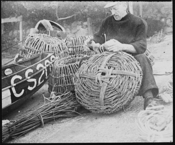 A fisherman making lobster pots at Steephill Cove, Ventnor, Isle Of Wight, 1930-1950. Creator: George R Long.