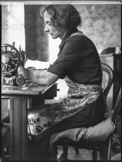 A glover or glove maker working at a sewing machine, Woodstock, Oxfordshire, 1920-1940.  Creator: George R Long.