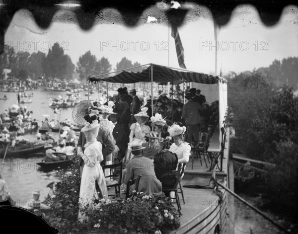 Men and women take tea on a college barge overlooking the Henley Royal Regatta, Oxfordshire, 1897. Creator: Henry Taunt.