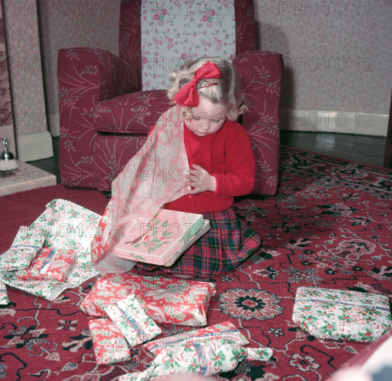 Girl opening her Christmas presents, c1955.  Creator: Arthur Charles Kirby Ware.