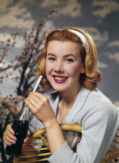 A young woman drinking a bottle of Coca-Cola, c1955.  Creator: Arthur Charles Kirby Ware.