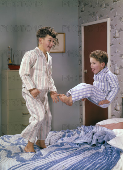 Two boys jumping on a bed, c1955.  Creator: Arthur Charles Kirby Ware.
