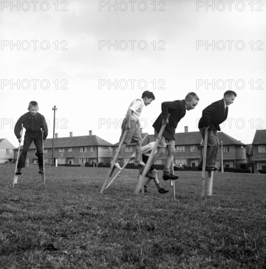 Children walking on stilts, c1955. Creator: Arthur Charles Kirby Ware.