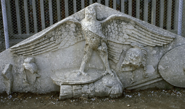 Eagle figure, armour, spear, helmet and circular shield, Roman gable, Side, Turkey, 1999. Creator: LTL.