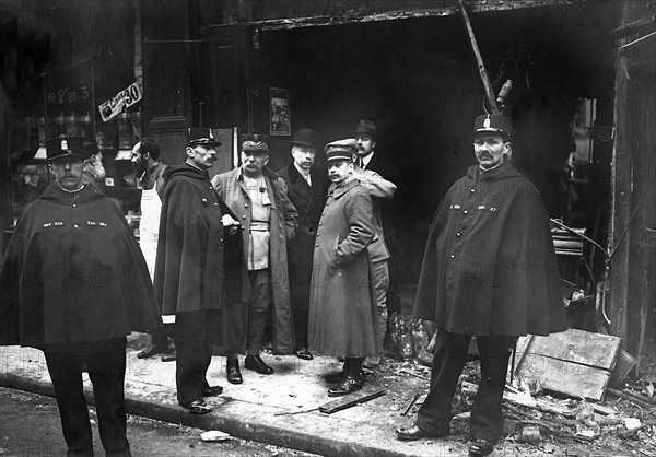 Des policiers accompagnés du général Parreau constatent les dégâts dans un magasin de la rue des Maronites - Les bombardements aériens de l'artillerie allemande sur Paris par les canons allemands à longue portée, les "Berthas" (fabriqués par les usines Jrupp), du 23 mars au 09 août 1918.