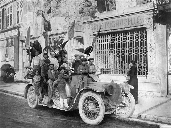 Enfants Saint-Mihiélois groupés sur la voiture d'un officier français qu'ils ont pavoisée, septembre 1918.