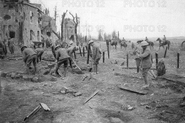 Canadiens nettoyant une route près de Cambrai. L'armée Canadienne en France. 1918, soldats nettoyant une route près de Cambrai.