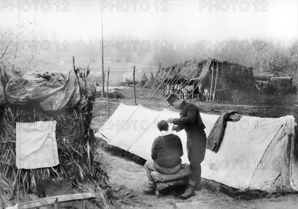 - La vie quotidienne des soldats sur le front dans les régions désolées de la champagne - Le barbier du village opérant en plein air