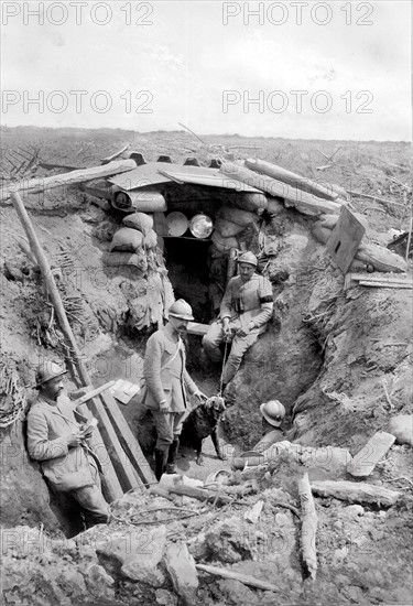 Première guerre mondiale. Juin 1917 sur le front. Poste optique sur le chemin des Dames. Au dessus de l'entrée de l'abri, on aperçoit l'appareil de signalisation; dans le groupe de soldat, situé dans la tranchée, un chien sentinelle.