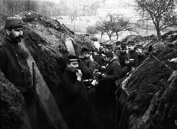 RAVITAILLEMENT DES SOLDATS SUR LA LIGNE DE FEU - En janvier 1915, dans une tranchée du front de l'Aisne en France, des soldats déjeunent sans quitter leur poste. Première Guerre Mondiale - Nous contacter pour la légende complète