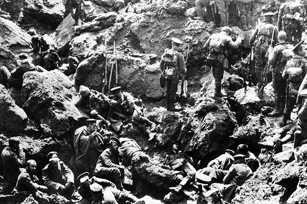 CRATERE APRES L'EXPLOSION D'UNE MINE EN FLANDRE - En 1915, en Flandre belge, des "Tommies" britanniques inspectent le cratère creusé par l'explosion d'une mine sur une position allemande. Leurs prisonniers, survivants de l'attaque côtoient les cadavres des victimes. Première Guerre Mondiale - Nous contacter pour la légende complète