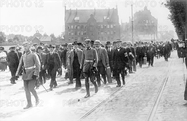 Fin juillet 1914, réservistes allemands se rendant à pied à une caserne de Berlin, quelques jours avant la déclaration de la Première Guerre mondiale.  Photographie parue dans L'Illustration du 4 août 1934, à l'occasion du 20ème anniversaire de la déclaration de la guerre. Première Guerre Mondiale - Nous contacter pour la légende complète