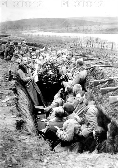 Noël dans une tranchée allemande - Première guerre mondiale. Dans une tranchée allemande, des soldats fëte noël, un musicien accompagne des chants de noël autour d'un sapin décoré.1914. Premiere guerre mondiale. Dans une tranchee allemande, des soldats fete noel, un musicien accompagne des chants de noel autour d'un sapin decore.1914.