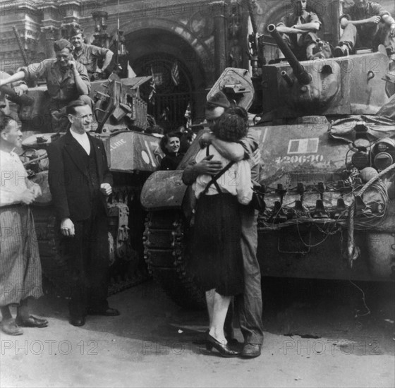 En août 1944, à la Libération de Paris, alors qu'on assiste à des scènes de liesse dans toute la capitale, une parisienne embrasse un soldat des forces alliées sur son véhicule.