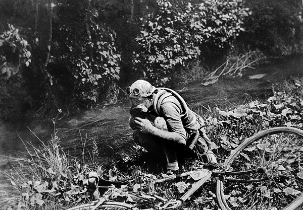 Tour de France 1924 : Lucien Buysse se lavant le visage dans un torrent des Alpes-de-Haute-Provence après être tombé dans la descente du col d'Allos. Photographie parue dans L'Illustration du 26 juillet 1924.