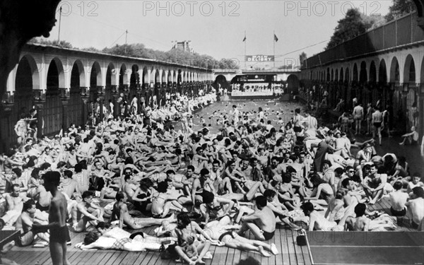 Le 10 mai 1952, à Paris, avec l'arrivée des premiers rayons de soleil, une foule de parisiens envahit la piscine DELIGNY, située sur la Seine, dans le VIIè arrondissement.