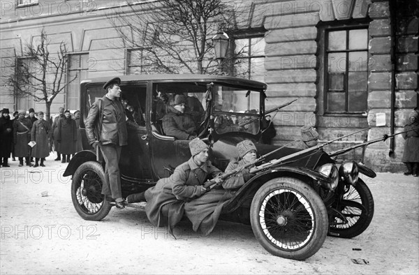 REVOLUTION RUSSE DE FEVRIER 1917 : : AUTO-ECLAIREURS A PETROGRAD - En mars 1917 (février selon le calendrier russe), à Petrograd (actuelle Saint-Petersbourg), des auto-éclaireurs perchés sur une automobiles visent des tireurs tsaristes camouflés en haut des toits. Quelques jours avant les émeutes de Petrograd ("Révolution de février"), les agents de police et gendarmes (surnommé PHARAONS) ont installé, sur ordre de PROTOPOPOFF, 300 mitrailleuses sur les toits des tours, églises et maisons de la ville. Ces émeutes provoqueront la chute du régime tsariste.