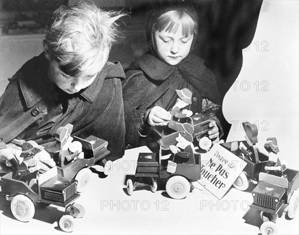 Enfants s'amusant avec les jouets exposés dans un grand magasin à Paris, 1954