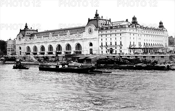 Paris, en 1900, vue depuis la Seine de la nouvelle gare d'Orsay, dite gare d'Orléans et de l'hôtel du Palais d'Orsay.  Construits en deux ans, à l'emplacement de l'ancienne Cour des Comptes (ou Palais d'Orsay) restée près de trente ans en ruines et rachetée par la Compagnie des Chemins de fer d'Orléans, la gare et son hôtel furent inaugurés pour l'Exposition Universelle, le 14 juillet 1900. Les travaux furent confiés à l'architecte Victor Laloux. Paris, en 1900, vue depuis la Seine de la nouvelle gare d'Orsay, dite gare d'Orleans et de l'hotel du Palais d'Orsay.  Construits en deux ans, a l'emplacement de l'ancienne Cour des Comptes (ou Palais d'Orsay) restee pres de trente ans en ruines et rachetee par la Compagnie des Chemins de fer d'Orleans, la gare et son hotel furent inaugures pour l'Exposition Universelle, le 14 juillet 1900. Les travaux furent confies a l'architecte Victor Laloux.