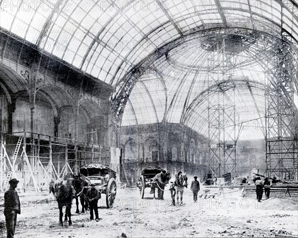 En mars 1900, la nef du Grand Palais en cours de construction avant son inauguration pour l'Exposition universelle de 1900 à Paris.  L'édifice est l'oeuvre des architectes Girault, Deglane, Louvet et Thomas. Photographie inédite du fonds L'Illustration.