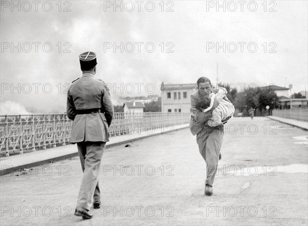 French journalist Raymond Vanker saving a baby, 1936