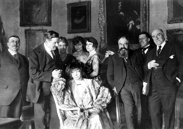 "Une fête de famille dans le monde des théâtres".  Le 11 avril 1919, après le mariage de Sacha Guitry et Yvonne Printemps, témoins, parents et amis sont réunis autour de Sarah Bernhardt dans l'hôtel de Lucien Guitry.  De gauche à droite: Herny Hertz, Georges Feydeau, Sarah Bernhardt, Tristan Bernard, Sacha et Lucien Guitry. Derrière Sarah Bernhardt: Mme Hertz, Yvonne Printemps et Jeanne Desclos.  Photographie parue dans L'Illustration du 19 avril 1919.