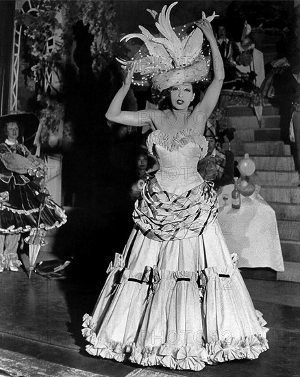 Le 5 mars 1949, à Paris, Joséphine BAKER, en costume de scène, chante et danse pour la Revue FÉERIES-FOLIES au BAL MABILLE, auréolée d'un chapeau de plumes.
