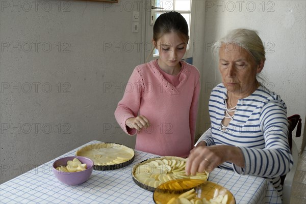 Girl making pastry with her grandmother