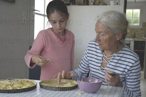 Girl making pastry with her grandmother