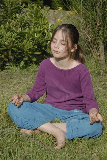 9 year-old child making yoga in a garden