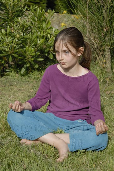 9 year-old child making yoga in a garden