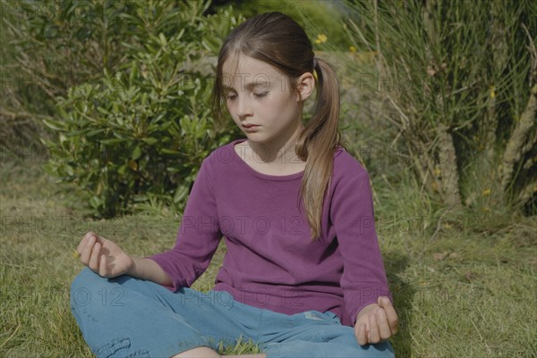 9 year-old child making yoga in a garden