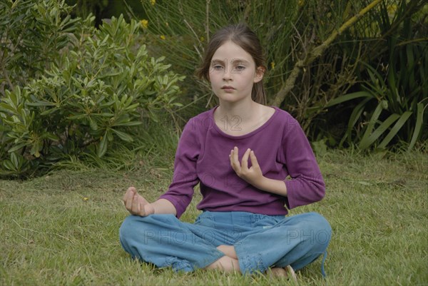 9 year-old child making yoga in a garden