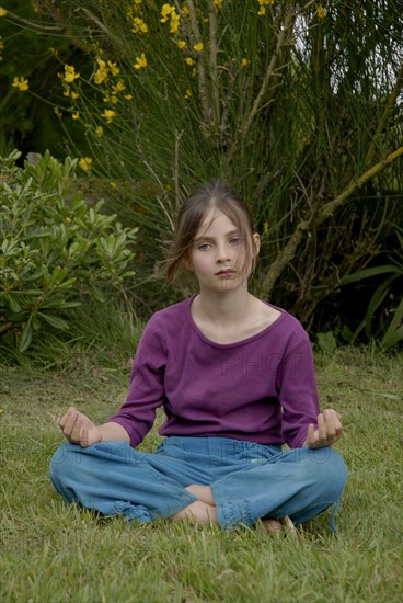 9 year-old child making yoga in a garden