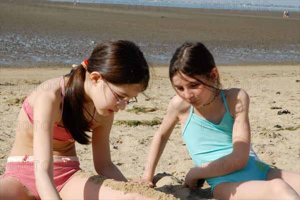 Girls talking and laying on sand