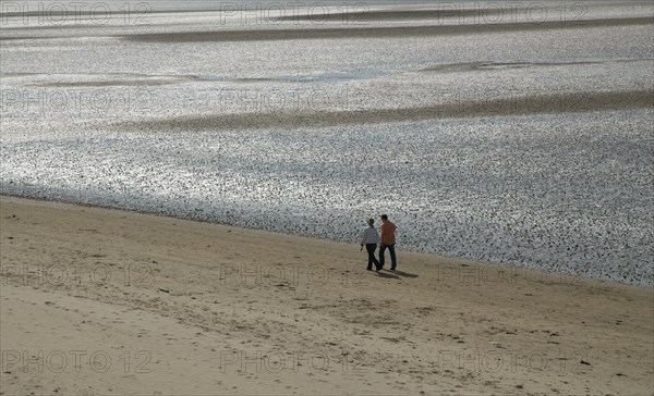 Couple walking on Ronce les Bains beach, France