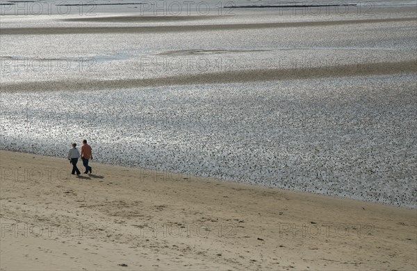 Couple walking on Ronce les Bains beach, France