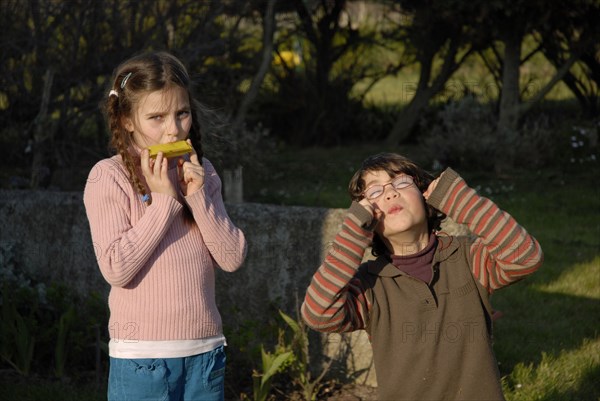 Fillette et garçon jouant dans un jardin