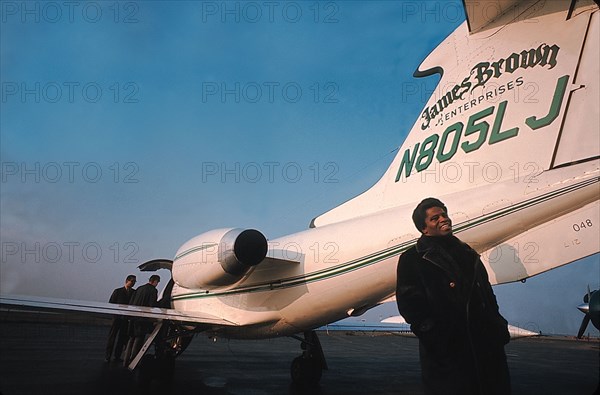 James Brown standing by his private airplane at the Long Island airport.